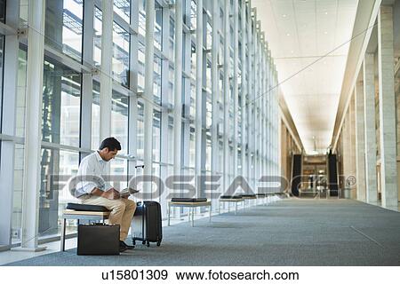 Stock Photo - Businessman working in lobby area. Fotosearch