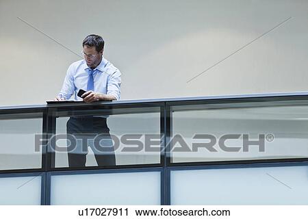 Stock Image - Businessman working on balcony. Fotosearch