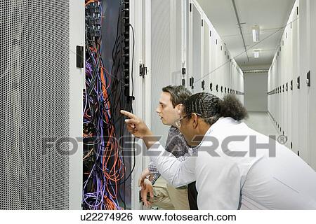 Businessmen examining wires in server View Large Photo Image Stock Photograph - Businessmen examining wires in server. Fotosearch