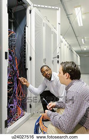 Businessmen examining wires in server View Large Photo Image Stock Photograph - Businessmen examining wires in server. Fotosearch