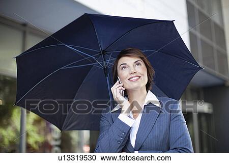 Businesswoman carrying umbrella outdoors View Large Photo Image Stock Image - Businesswoman carrying umbrella outdoors. Fotosearch