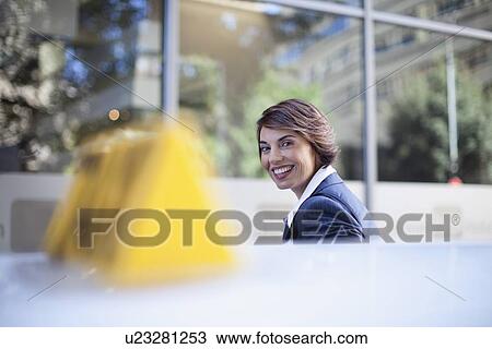 Stock Image - Businesswoman climbing out of taxi. Fotosearch