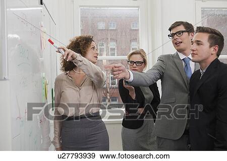 Stock Photo - Businesswoman pointing to whiteboard. Fotosearch
