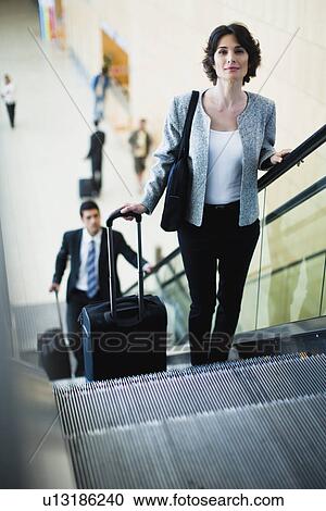 Businesswoman riding escalator View Large Photo Image Stock Image - Businesswoman riding escalator. Fotosearch