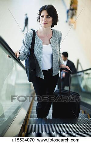 Businesswoman riding escalator View Large Photo Image Stock Image - Businesswoman riding escalator. Fotosearch