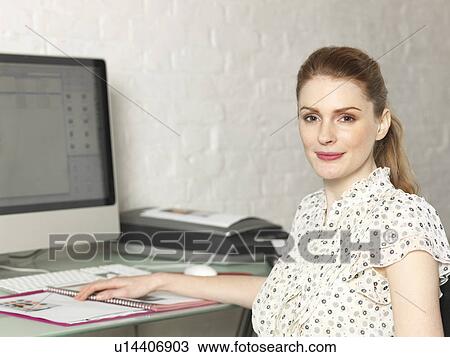 Businesswoman smiling at desk View Large Photo Image Stock Image - Businesswoman smiling at desk. Fotosearch