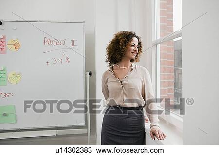 Businesswoman smiling at office window View Large Photo Image Stock Image - Businesswoman smiling at office window. Fotosearch