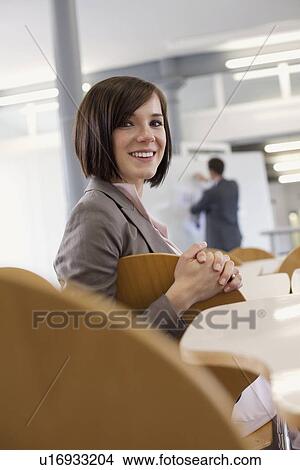 Picture - Businesswoman smiling in chair. Fotosearch