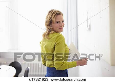 Stock Image - Businesswoman smiling in office. Fotosearch