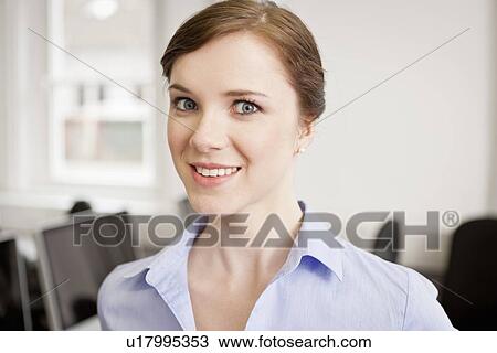 Stock Image - Businesswoman smiling in office. Fotosearch