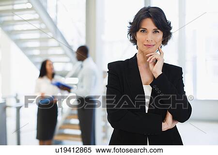 Businesswoman smiling in office View Large Photo Image Stock Photography - Businesswoman smiling in office. Fotosearch