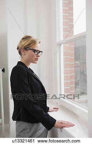 Businesswoman standing at window View Large Photo Image Stock Image - Businesswoman standing at window. Fotosearch