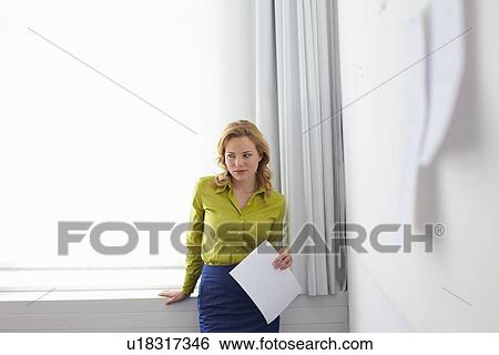 Stock Photograph - Businesswoman standing in office. Fotosearch
