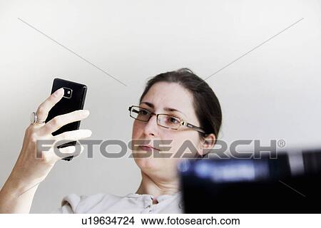 Picture - Businesswoman using cell phone. Fotosearch