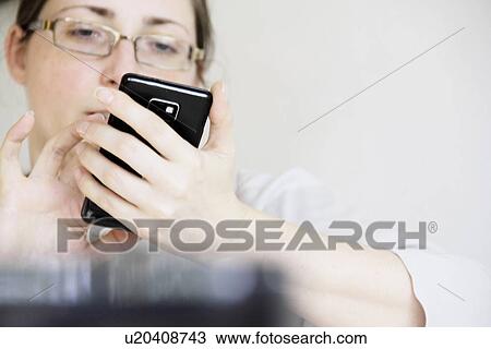 Stock Image - Businesswoman using cell phone. Fotosearch