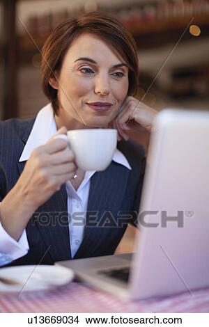 Businesswoman using laptop in cafe View Large Photo Image Picture - Businesswoman using laptop in cafe. Fotosearch