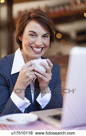 Businesswoman using laptop in cafe View Large Photo Image Stock Photo - Businesswoman using laptop in cafe. Fotosearch
