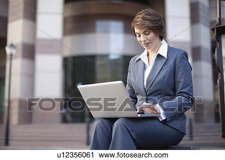 Businesswoman using laptop outdoors View Large Photo Image Stock Image - Businesswoman using laptop outdoors. Fotosearch