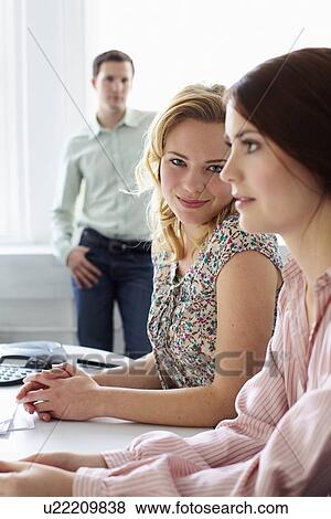 Stock Photo - Businesswomen sitting together in office. Fotosearch