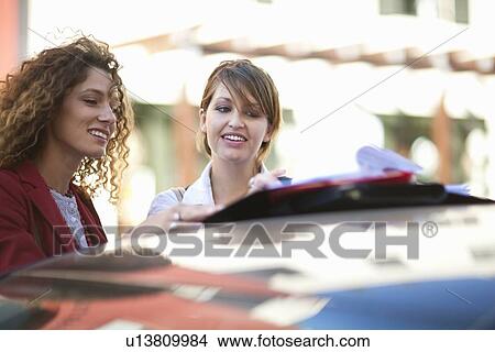 Businesswomen talking at car outdoors View Large Photo Image Picture - Businesswomen talking at car outdoors. Fotosearch