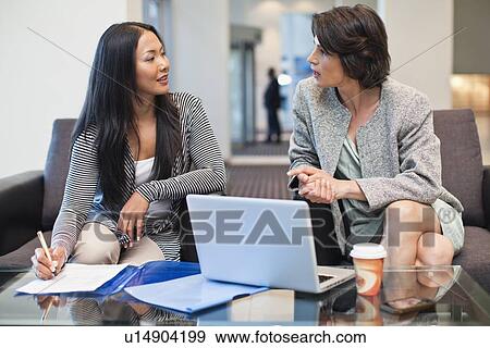 Stock Photo - Businesswomen working together. Fotosearch