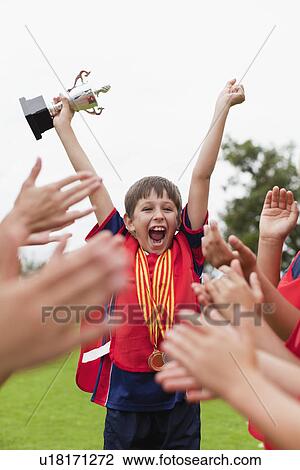 Children cheering teammate with trophy View Large Photo Image Stock Image - Children cheering teammate with trophy. Fotosearch