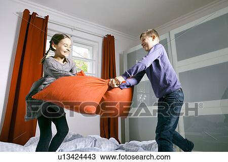 Children having pillow fight on bed View Large Photo Image Stock Image - Children having pillow fight on bed. Fotosearch