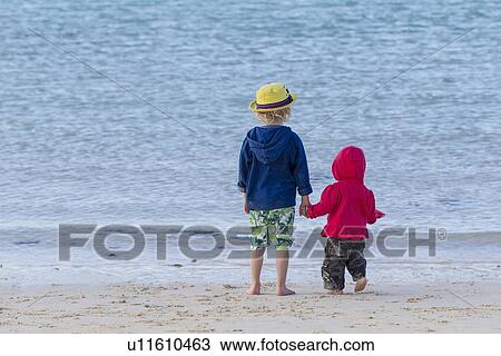 Children holding hands on sandy beach View Large Photo Image Stock Image - Children holding hands on sandy beach. Fotosearch