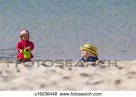 Stock Photo - Children playing on sandy beach. Fotosearch