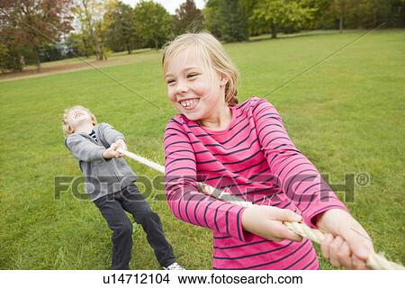 Picture - Children playing tug-of-war outdoors. Fotosearch