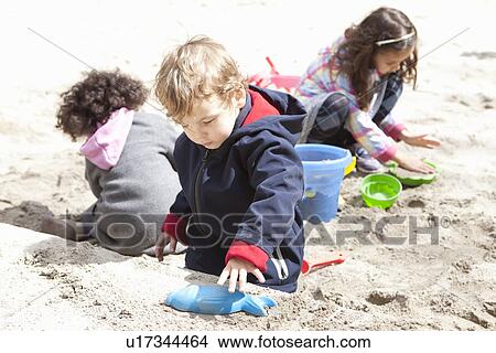 Picture - Children playing with sand in playground. Fotosearch