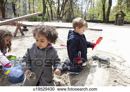 Children playing with sand in playground View Large Photo Image Stock Image - Children playing with sand in playground. Fotosearch