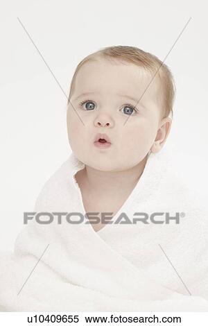 Stock Photography - Close up of baby girl wearing bathrobe. Fotosearch