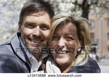 Stock Photo - Close up of couples smiling faces. Fotosearch