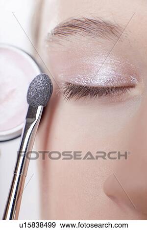 Stock Photo - Close up of girl applying makeup. Fotosearch