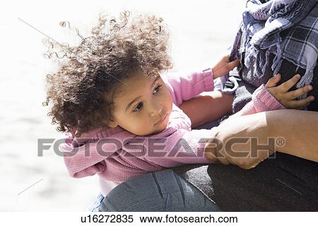 Stock Photography - Close up of girl hugging mother outdoors. Fotosearch