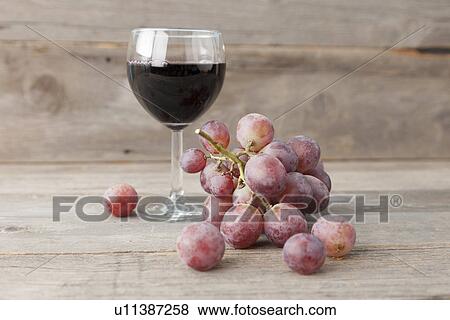 Stock Photo - Close up of grapes and glass of wine. Fotosearch