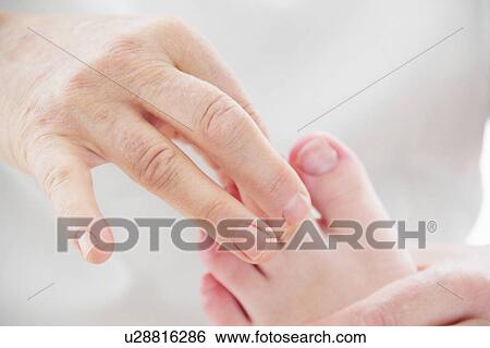 Stock Photograph - Close up of masseuse working on feet. Fotosearch