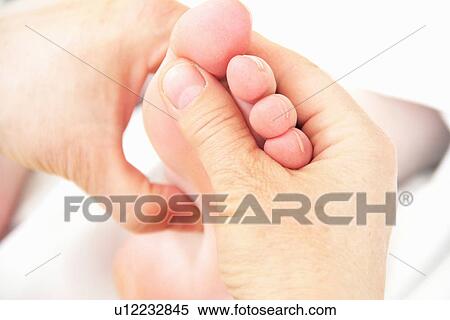 Stock Photography - Close up of masseuse working on feet. Fotosearch
