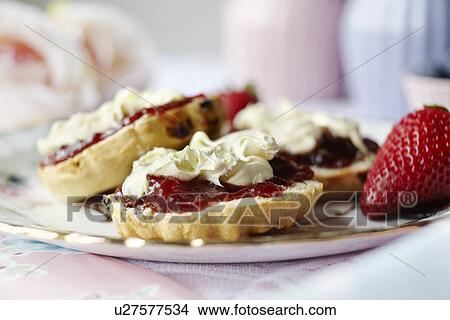 Picture - Close up of sliced scone with jam. Fotosearch
