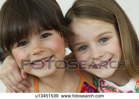 Close up of smiling girls hugging View Large Photo Image Stock Photo - Close up of smiling girls hugging. Fotosearch