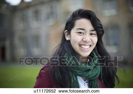 Stock Image - Close up of student smiling outdoors. Fotosearch
