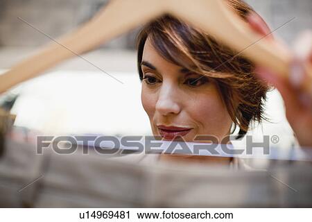Close up of woman examining clothes View Large Photo Image Stock Image - Close up of woman examining clothes. Fotosearch