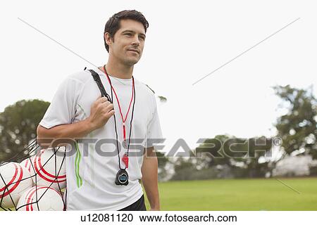 Coach carrying soccer balls on pitch View Large Photo Image Stock Image - Coach carrying soccer balls on pitch. Fotosearch