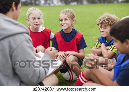 Coach talking to childrens soccer team View Large Photo Image Stock Photo - Coach talking to childrens soccer team. Fotosearch