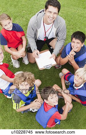 Stock Photography - Coach talking to childrens soccer team. Fotosearch