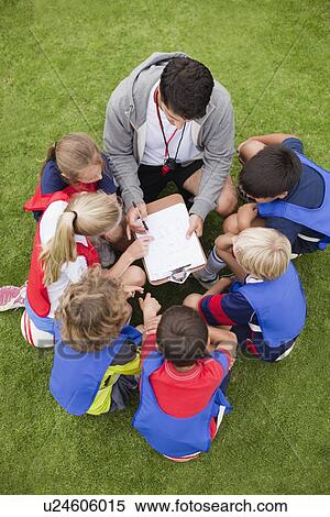 Stock Photography - Coach talking to childrens soccer team. Fotosearch
