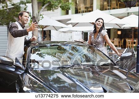 Stock Photography - Couple climbing out of car. Fotosearch