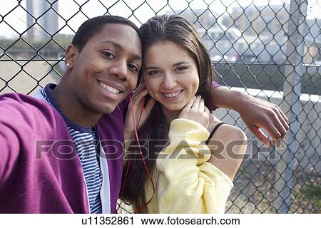 Stock Image - Couple hugging on city street. Fotosearch