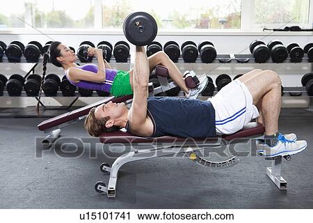 Couple lifting weights in gym View Large Photo Image Stock Image - Couple lifting weights in gym. Fotosearch